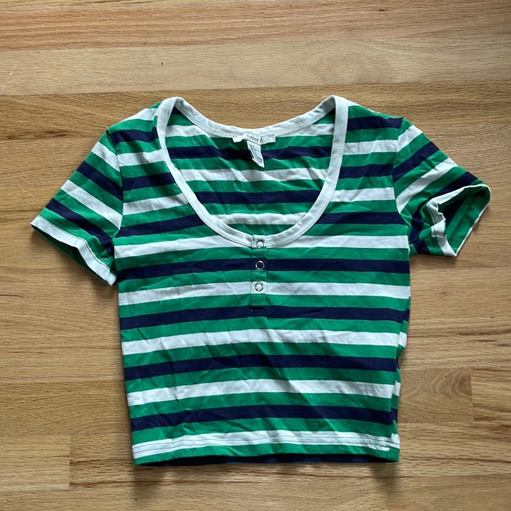 a green t shirt with white and navy stripes.